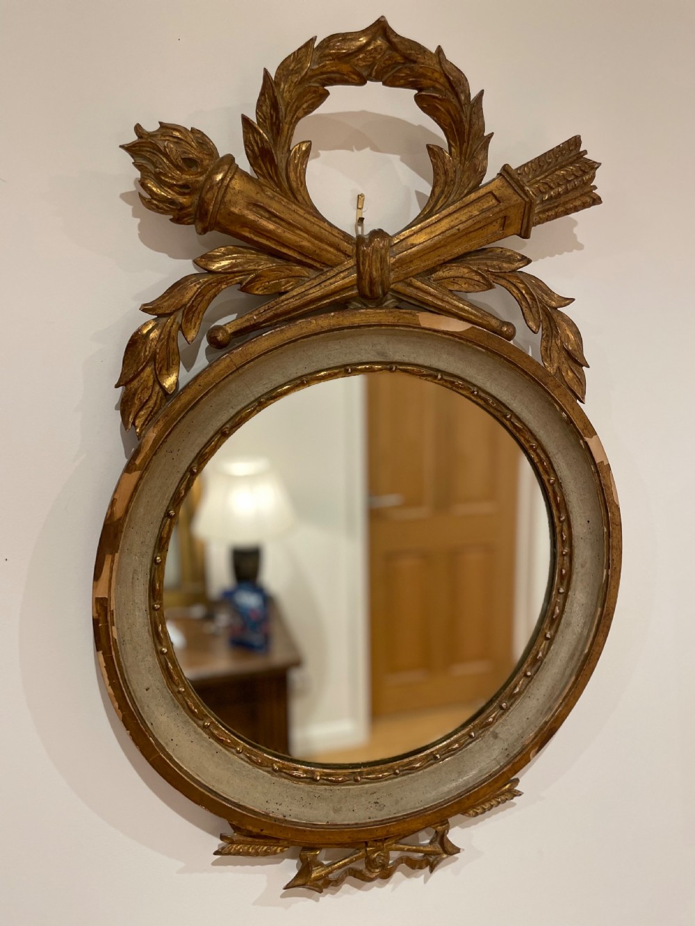 round mirror with torch and quiver cresting